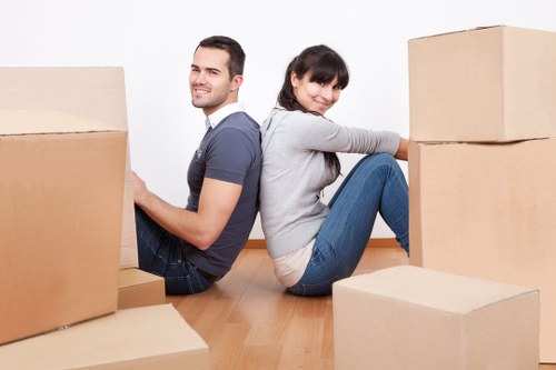 Two movers lifting a heavy item using safe manual handling techniques